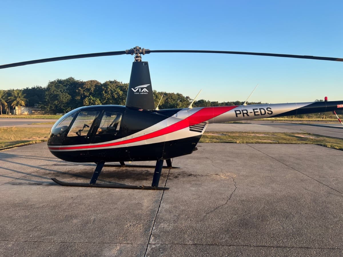 Helicóptero Robinson R44 II PR-EDS da Via Táxi Aéreo estacionado no pátio ao entardecer — foto publicada no site da empresa